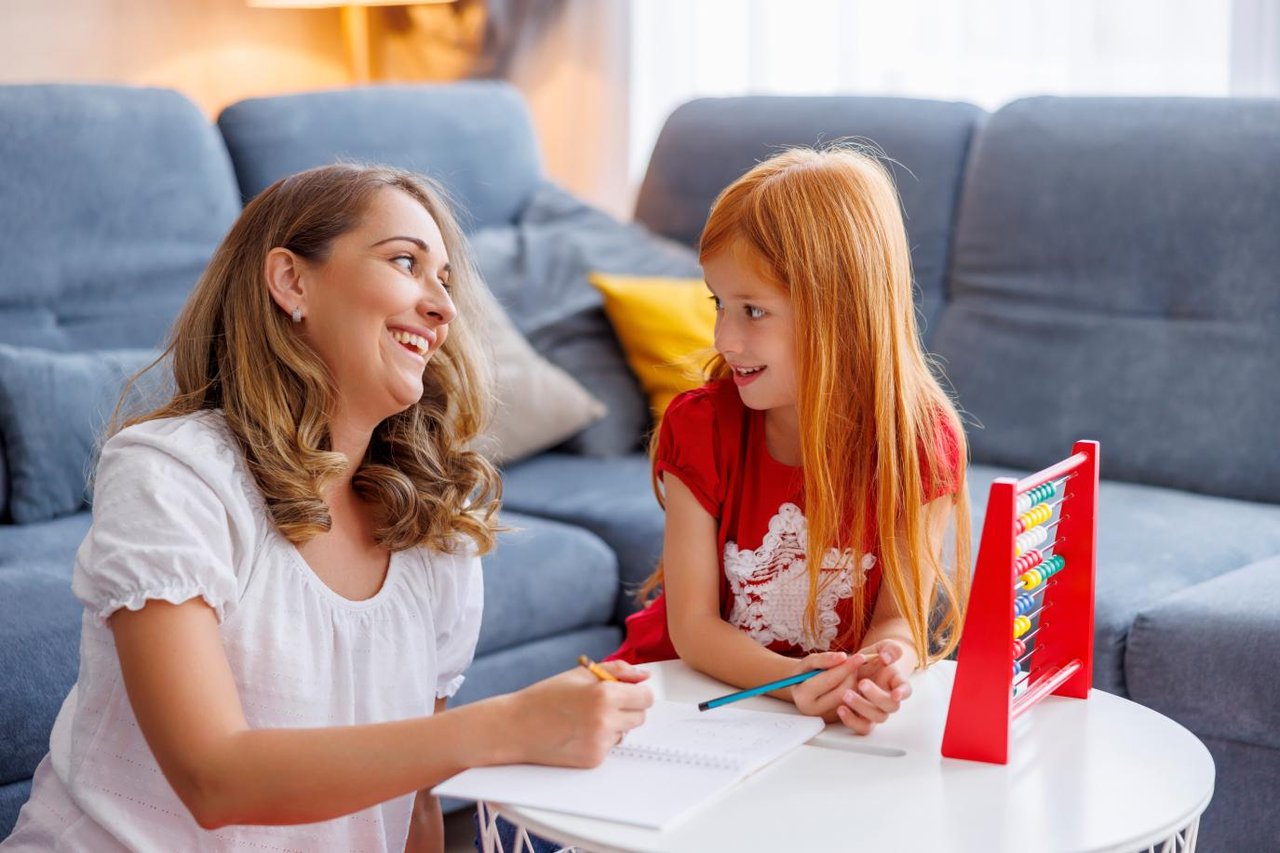 Mother and daughter working on maths homework with an abacus 