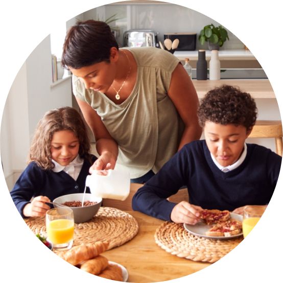 Mother serving breakfast to her two schoolchildren