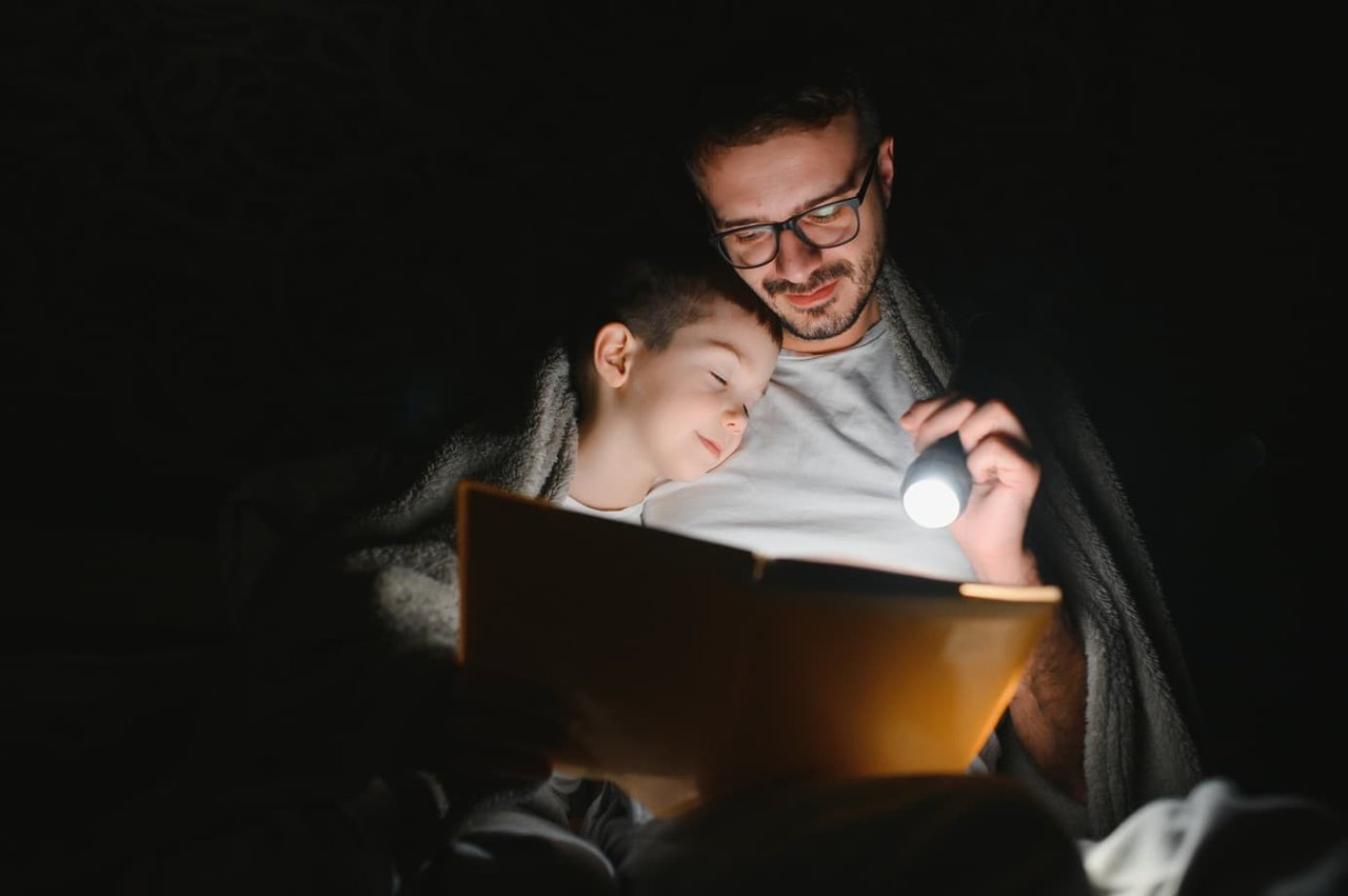 A father reading a bedtime story to his son