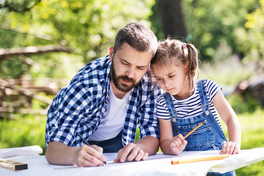 A father and daughter measuring outside in the sun