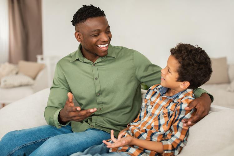 A father and son having a conversation, smiling together