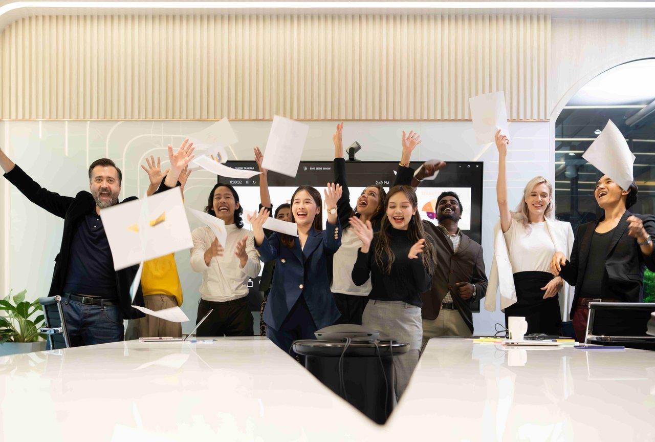 A group of students celebrating results, all holding pieces of paper