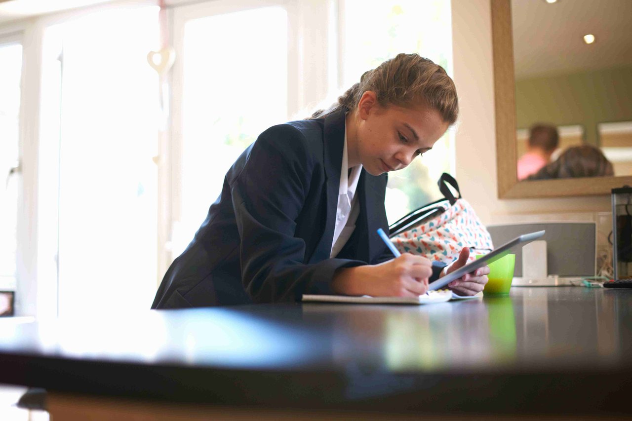 Year 10 girl, working on the kitchen table at home