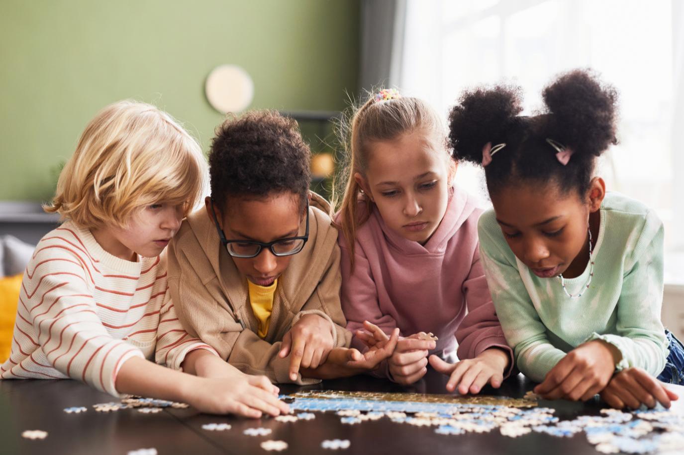Four children putting together a puzzle on a table