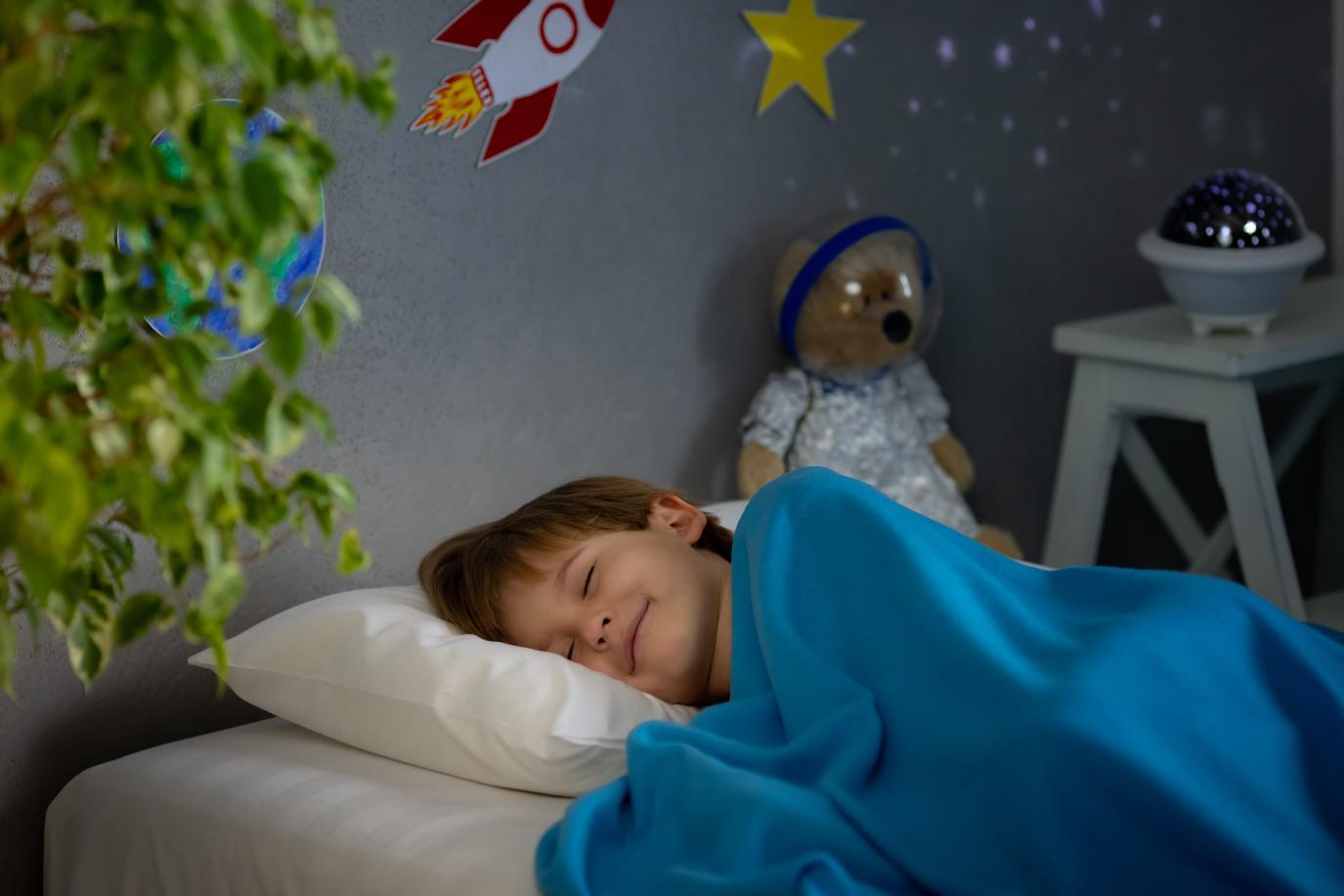 Happy child sleeping in his bedroom