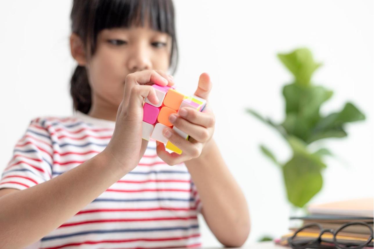 Young girl playing with a Rubiks Cube